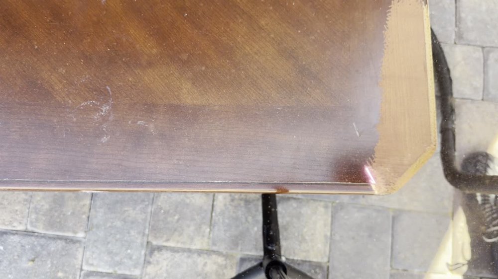 Laser cleaning removing a finish from a wooden tabletop